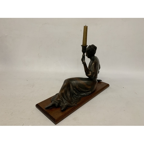 10 - A LARGE ART NOUVEAU FIGURE OF A RECLING LADY CANDLESTICK ON AN OAK BASE, HEIGHT 18CM, WIDTH 45CM