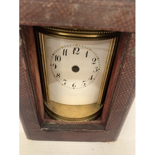 34 - AN ANTIQUE CYLINDRICAL BRASS CARRIAGE CLOCK WITH VISIBLE ESCAPEMENT IN A LEATHER TRAVELLING CASE