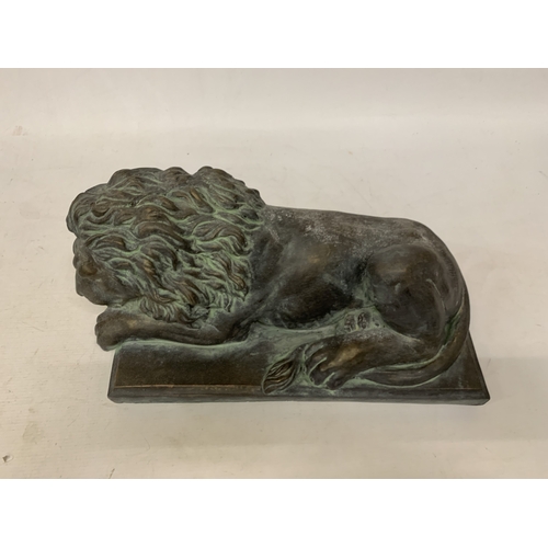 25 - A CARVED SERPENTINE MODEL OF A RECUMBENT SLEEPING LION - 40 CM (L)