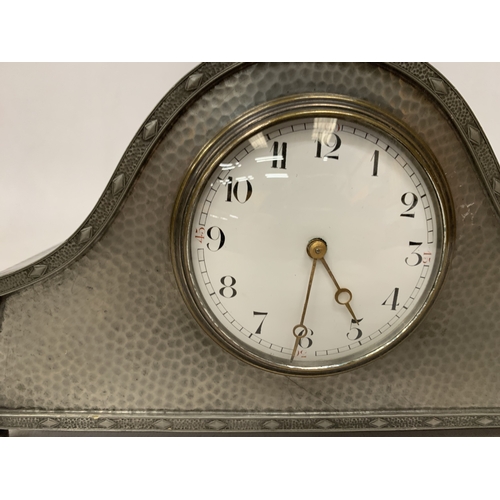 46 - AN ARTS & CRAFTS PEWTER HAMMERED NAPOLEON'S HAT SHAPED MANTEL CLOCK