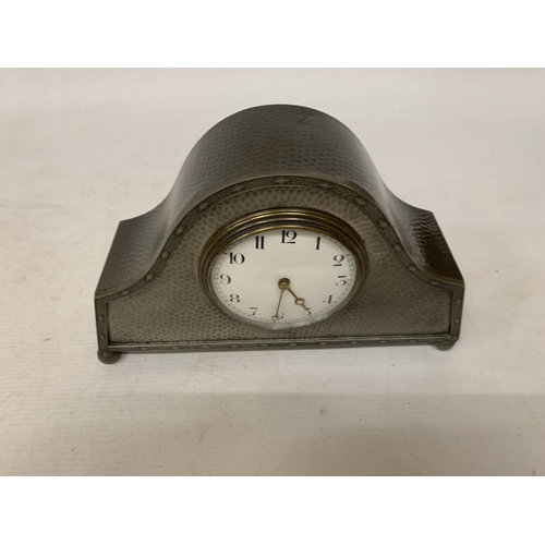 46 - AN ARTS & CRAFTS PEWTER HAMMERED NAPOLEON'S HAT SHAPED MANTEL CLOCK