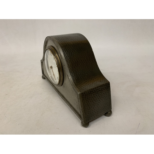 46 - AN ARTS & CRAFTS PEWTER HAMMERED NAPOLEON'S HAT SHAPED MANTEL CLOCK