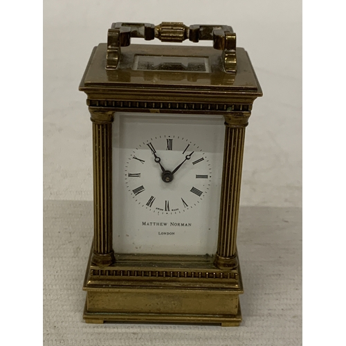 18 - A VINTAGE MATTHEW NORMAN LONDON MINIATURE CARRIAGE CLOCK IN A BRASS CORINTHIAN CASE WITH BEVELED GLA... 