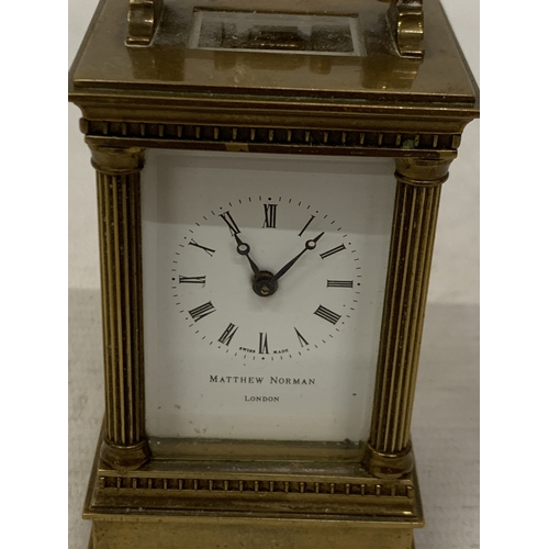 18 - A VINTAGE MATTHEW NORMAN LONDON MINIATURE CARRIAGE CLOCK IN A BRASS CORINTHIAN CASE WITH BEVELED GLA... 