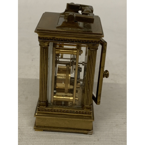 18 - A VINTAGE MATTHEW NORMAN LONDON MINIATURE CARRIAGE CLOCK IN A BRASS CORINTHIAN CASE WITH BEVELED GLA... 