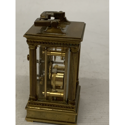 18 - A VINTAGE MATTHEW NORMAN LONDON MINIATURE CARRIAGE CLOCK IN A BRASS CORINTHIAN CASE WITH BEVELED GLA... 