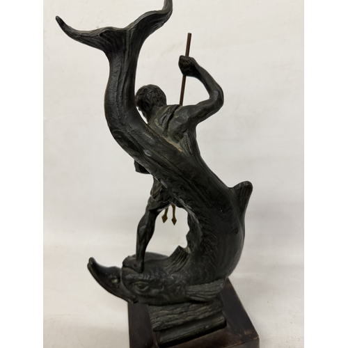 16 - A PATINATED BRONZE SCULPTURE OF NEPTUNE HOLDING A TRIDENT WHILST STANDING ON A STYLIZED SEA CREATURE... 