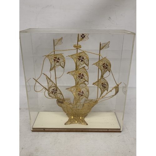 24 - A MODEL OF A GILT GALLEON WITH ENAMEL FLAGS IN A CASE, HEIGHT 33CM, WIDTH 30CM, DEPTH 10CM