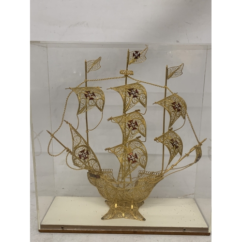 24 - A MODEL OF A GILT GALLEON WITH ENAMEL FLAGS IN A CASE, HEIGHT 33CM, WIDTH 30CM, DEPTH 10CM