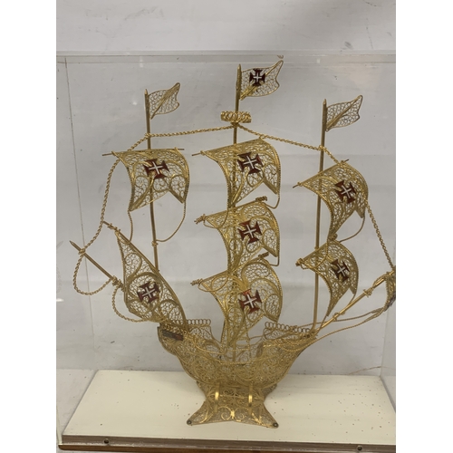 24 - A MODEL OF A GILT GALLEON WITH ENAMEL FLAGS IN A CASE, HEIGHT 33CM, WIDTH 30CM, DEPTH 10CM