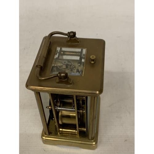 30 - A FRENCH BRASS CARRIAGE CLOCK WITH GLASS ESCAPEMENT (ONE PANE MISSING)