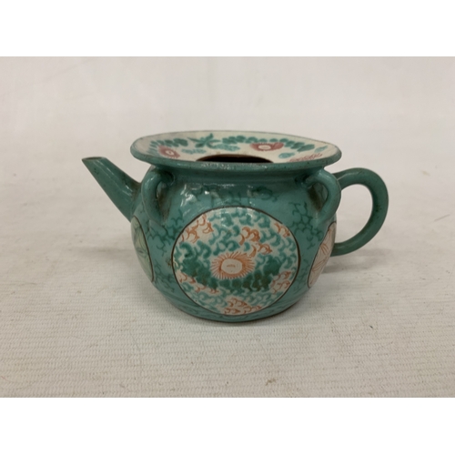44 - A CHINESE ENAMELLED YIXING TEAPOT WITH A GREEN GLAZED BODY AND ENAMELLED FLORAL DECORATION
