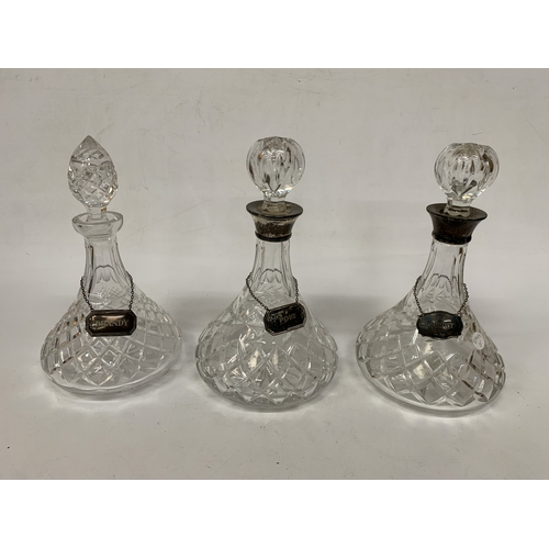 2 - THREE VINTAGE CUT GLASS DECANTERS WITH HALLMARKED SILVER LABELS AND HALLMARKED SILVER RIMS TO TWO OF... 