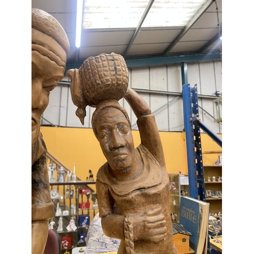 68 - TWO LARGE WOODEN CARVED FIGURES OF A BLACKSMITH AND A LADY WITH A BASKET ON HER HEAD, HEIGHT 68CM