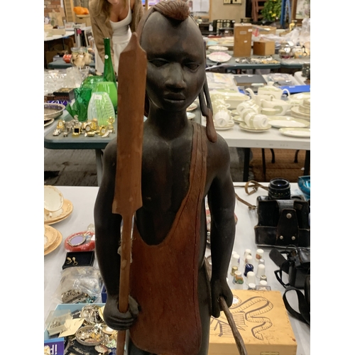 112 - A LARGE TRIBAL FIGURE HOLDING A SPEAR TOGETHER WITH A FURTHER SMALLER TRIBAL FIGURE