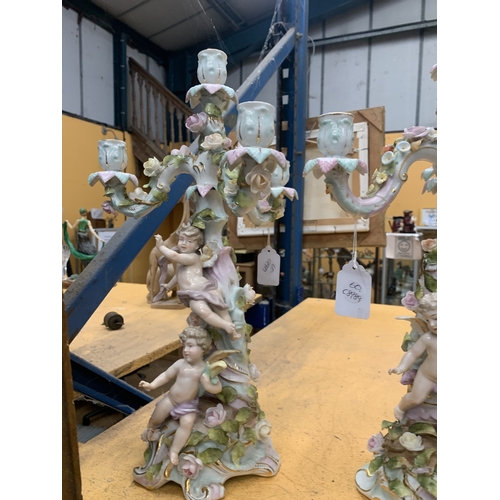 51 - A PAIR OF GERMAN PORCELAIN FIGURAL CANDELABRAS WITH A CHERUB FIGURAL DESIGN AND FLORAL ENCRUSTATIONS... 