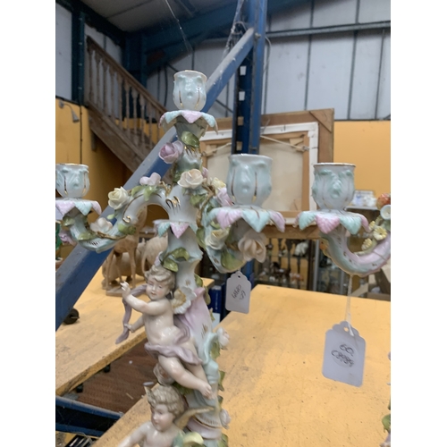 51 - A PAIR OF GERMAN PORCELAIN FIGURAL CANDELABRAS WITH A CHERUB FIGURAL DESIGN AND FLORAL ENCRUSTATIONS... 