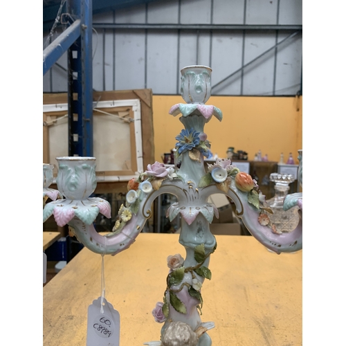 51 - A PAIR OF GERMAN PORCELAIN FIGURAL CANDELABRAS WITH A CHERUB FIGURAL DESIGN AND FLORAL ENCRUSTATIONS... 