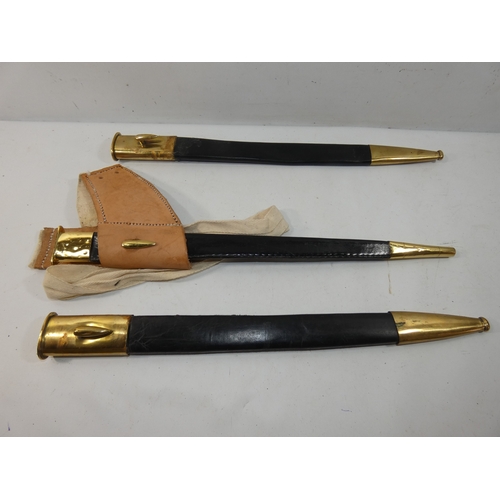 331 - A COLLECTION OF THREE BRASS AND LEATHER SCABBARDS, ONE FOR A SOCKET BAYONET, LENGTHS 45CM