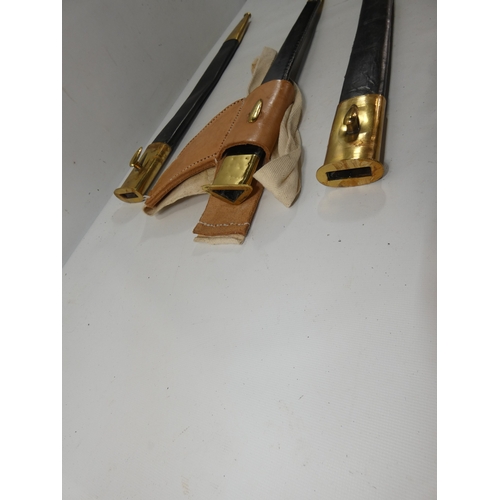 331 - A COLLECTION OF THREE BRASS AND LEATHER SCABBARDS, ONE FOR A SOCKET BAYONET, LENGTHS 45CM