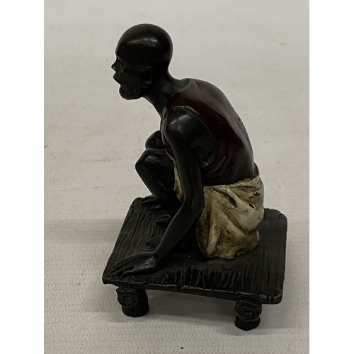 13 - A BRONZE COLD PAINTED FIGURE OF A SQUATTING MAN, HEIGHT 11 CM