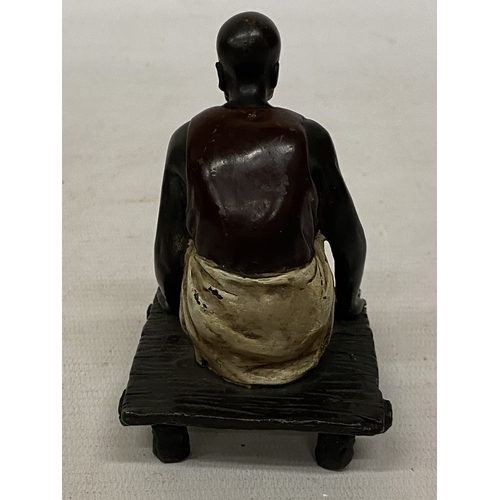 13 - A BRONZE COLD PAINTED FIGURE OF A SQUATTING MAN, HEIGHT 11 CM