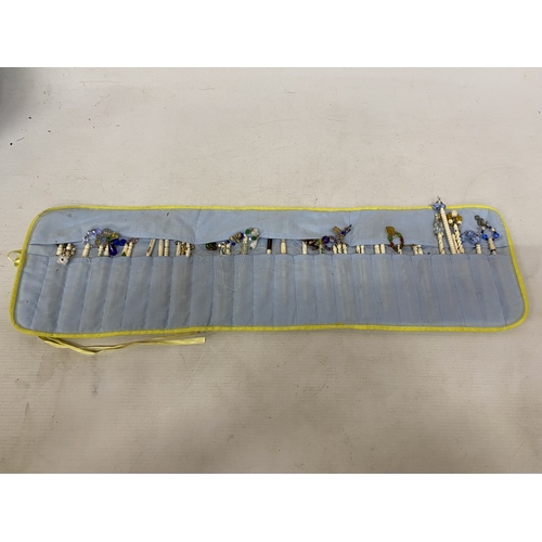 23 - A COLLECTION (APPROX 36) OF BONE LACE MAKING BOBBINS WITH CHARMS AND SPANGLES IN A POUCH