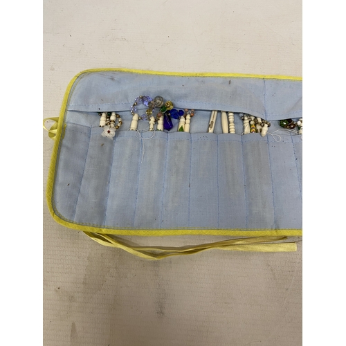 23 - A COLLECTION (APPROX 36) OF BONE LACE MAKING BOBBINS WITH CHARMS AND SPANGLES IN A POUCH