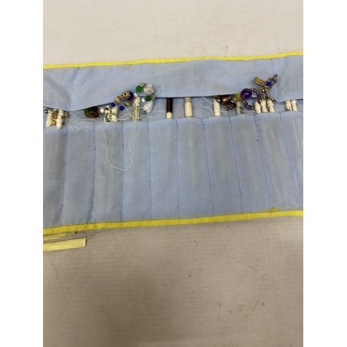 23 - A COLLECTION (APPROX 36) OF BONE LACE MAKING BOBBINS WITH CHARMS AND SPANGLES IN A POUCH