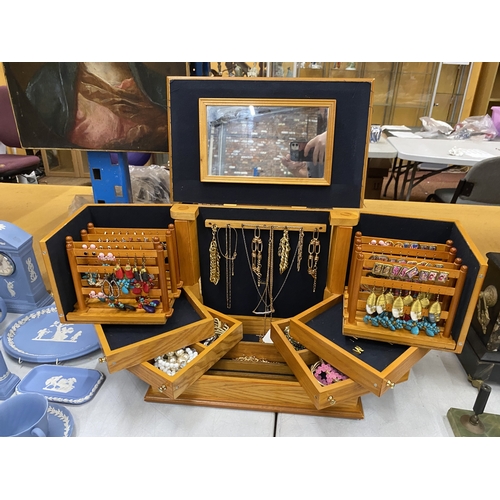 33 - A LARGE PINE JEWELLERY BOX WITH VARIOUS COMPARTMENTS AND MIRROR CONTAING A QUANTITY OF COSTUME JEWEL... 