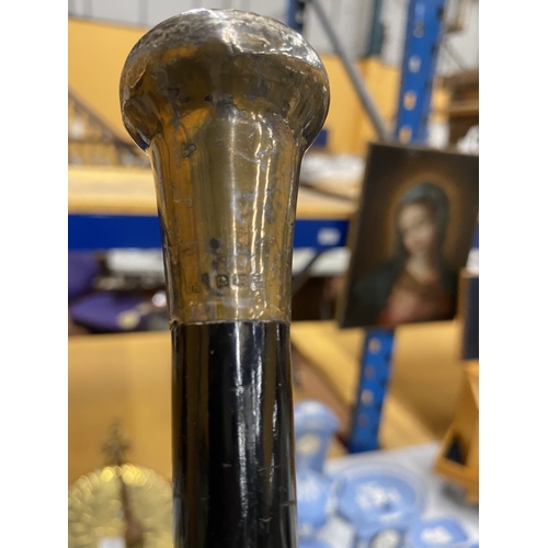 50 - A VINTAGE WALKING CANE WITH A DARK EBONIZED WOODEN SHAFT AND HALLMARKED BIRMINGHAM SILVER HANDLE