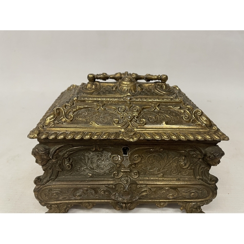11 - A GILDED CASKET WITH REPOUSSE FLORAL AND SCROLL DECORATION WITH CHERUB ACCENTS IN THE CORNERS WITH K... 