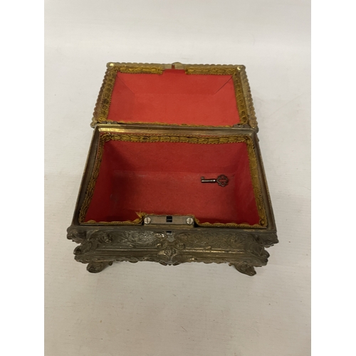 11 - A GILDED CASKET WITH REPOUSSE FLORAL AND SCROLL DECORATION WITH CHERUB ACCENTS IN THE CORNERS WITH K... 