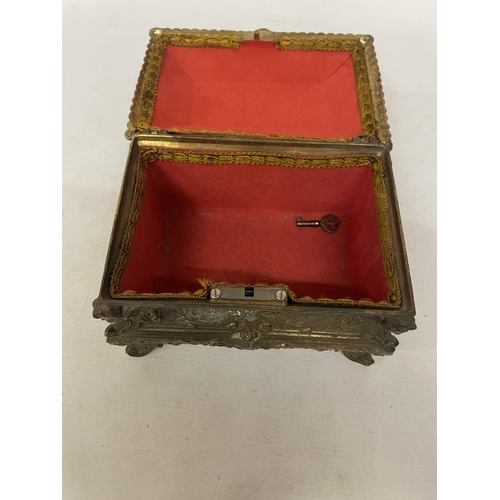 11 - A GILDED CASKET WITH REPOUSSE FLORAL AND SCROLL DECORATION WITH CHERUB ACCENTS IN THE CORNERS WITH K... 