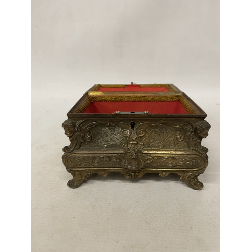 11 - A GILDED CASKET WITH REPOUSSE FLORAL AND SCROLL DECORATION WITH CHERUB ACCENTS IN THE CORNERS WITH K... 