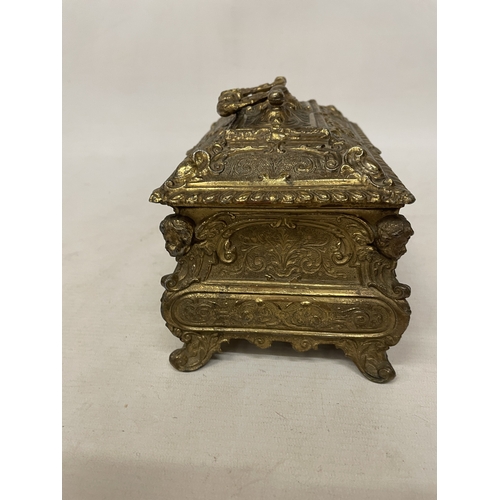 11 - A GILDED CASKET WITH REPOUSSE FLORAL AND SCROLL DECORATION WITH CHERUB ACCENTS IN THE CORNERS WITH K... 