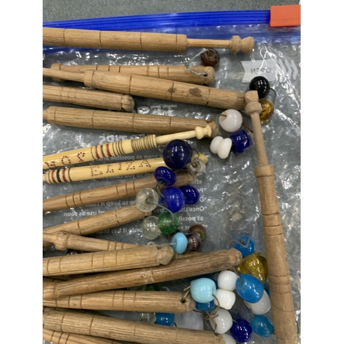 A COLLECTION OF WOODEN AND CARVED BONE BOBBINS WITH GLASS SPANGLES