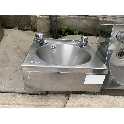 A SMALL STAINLESS STEEL HAND SINK WITH HOT AND COLD TAPS - NO VAT