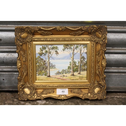 48 - A SMALL GILT FRAMED AUSTRALIAN STYLE OIL ON BOARD OF A MOUNTAINOUS COUNTRY LAKE SCENE SIGNED B KOSTE... 