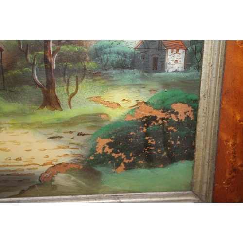 24 - A SATINWOOD FRAMED REVERSE PAINTING ON GLASS DEPICTING A CHURCH BESIDE A RIVER A/F - SIZE 60CM X 41C... 