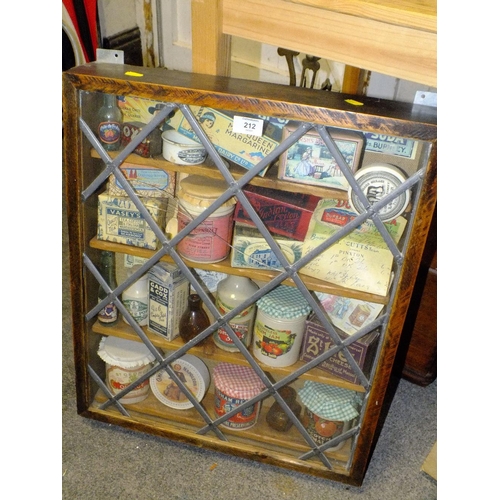 212 - A WALL HANGING OAK LEADED GLAZED DISPLAY CASE CONTAINING VINTAGE JARS AND TINS, S/D