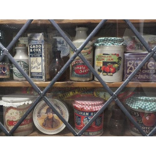 212 - A WALL HANGING OAK LEADED GLAZED DISPLAY CASE CONTAINING VINTAGE JARS AND TINS, S/D