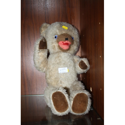 225A - A VINTAGE JOINTED TEDDY BEAR WITH GLASS EYES AND PULL STRING