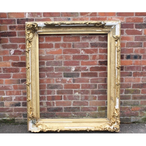 45 - A LARGE 19TH CENTURY GOLD DECORATIVE SWEPT FRAME - WITH DAMAGES, frame W 17 cm, rebate 120 x 97 cm