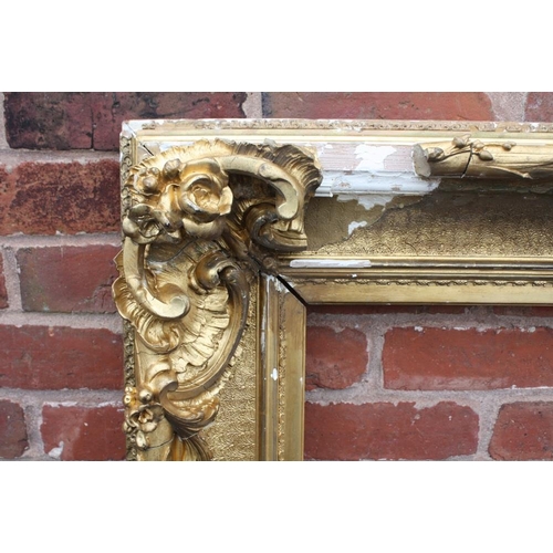 52 - A LARGE 19TH CENTURY GOLD DECORATIVE SWEPT FRAME - WITH DAMAGES, frame W 17 cm, rebate 120 x 97 cm