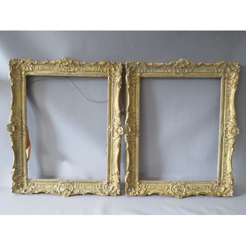 82 - A PAIR OF 20TH CENTURY DECORATIVE GILT SWEPT FRAMES, frame W 7 cm, rebate 51 x 39 cm