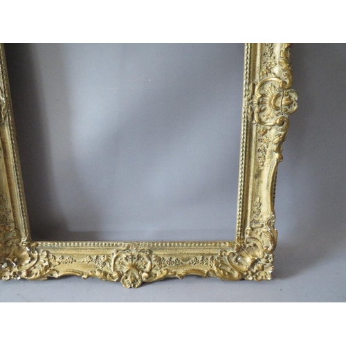 82 - A PAIR OF 20TH CENTURY DECORATIVE GILT SWEPT FRAMES, frame W 7 cm, rebate 51 x 39 cm