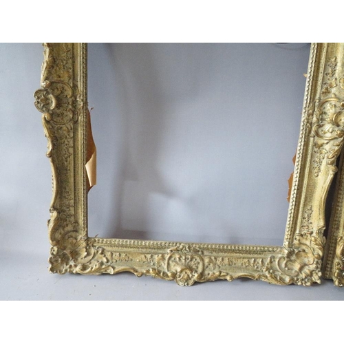 82 - A PAIR OF 20TH CENTURY DECORATIVE GILT SWEPT FRAMES, frame W 7 cm, rebate 51 x 39 cm
