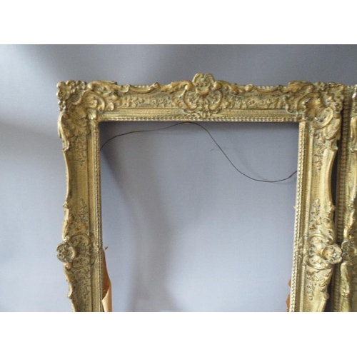 82 - A PAIR OF 20TH CENTURY DECORATIVE GILT SWEPT FRAMES, frame W 7 cm, rebate 51 x 39 cm