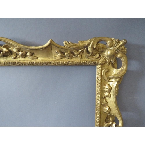 84 - A 19TH CENTURY CARVED WOODEN DECORATIVE GILT SWEPT FRAME, frame W 7 cm, rebate 58 x 42 cm